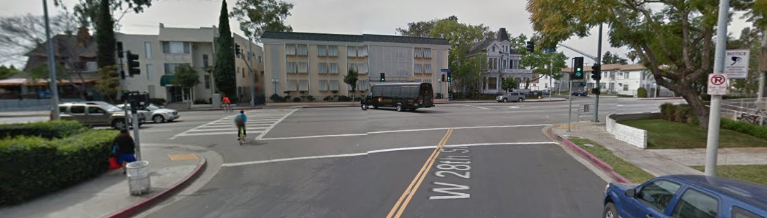 Google Street View of 28th and Hoover, a dog-legged intersection and two cyclists riding across a crosswalk